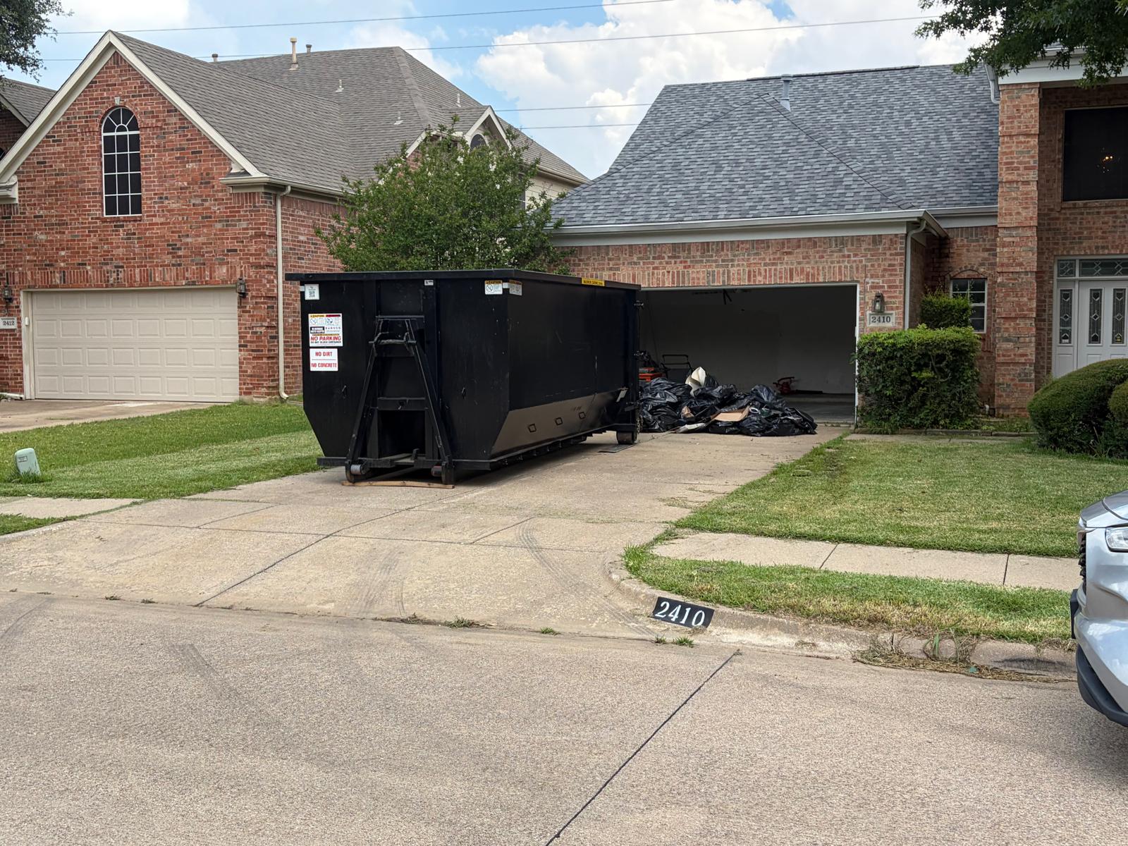 Lone Wolf Dumpsters roll-off container full of junk and debris ready for full-service haul-away in Dallas-Fort Worth