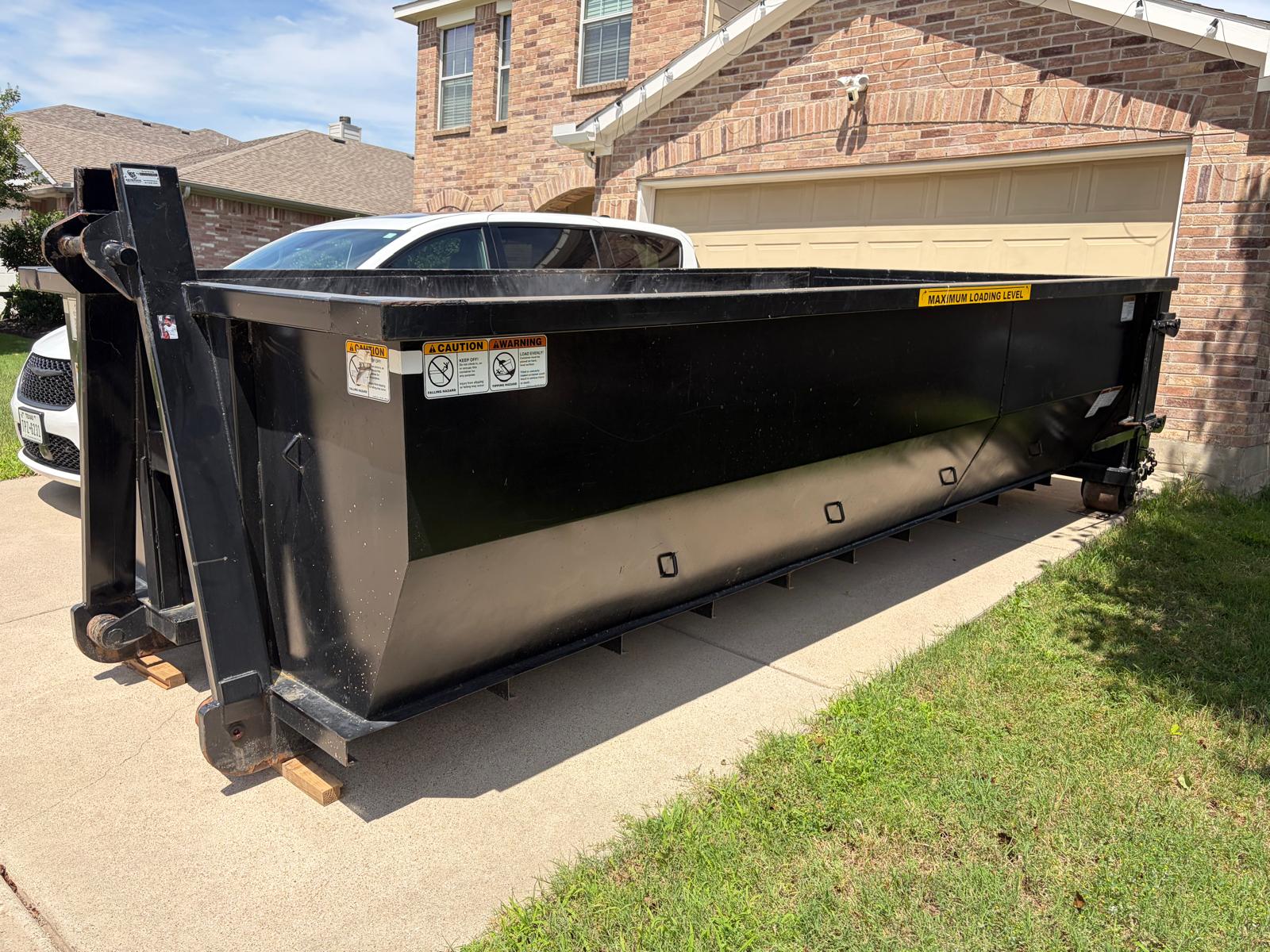 Residential dumpster rental on driveway in front of a home in Dallas-Fort Worth